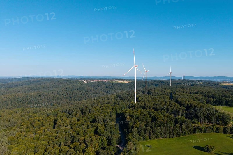Three wind turbines rise above lush forest and green countryside, near Schorndorf, Rems Valley, Baden-Württemberg, Germany
