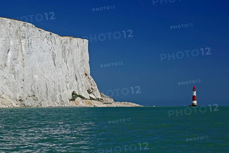 White cliff top next to a red and white lighthouse under a clear blue sky by the sea, Old Harrys Rock, Beachy Head Lighthouse, Bournemouth, Dorset, England, Great Britain
