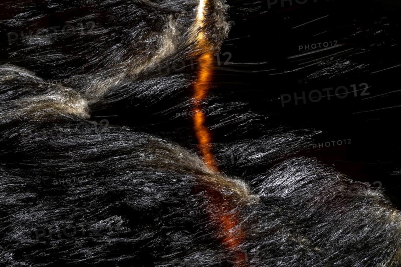 Branch of a birch tree in a fast flowing stream, light reflections on the water surface, Norway