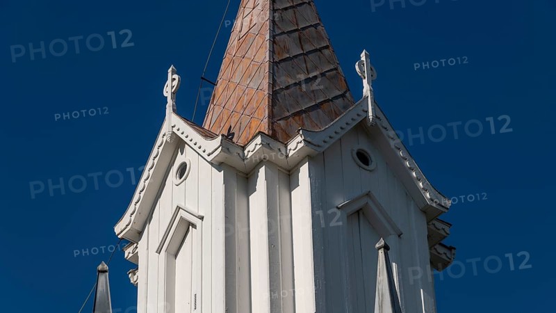 Pointed church tower with wooden elements and clear blue sky in the background, Tangen kirke or church, Olavsweg or Olavsleden, pilgrimage route, Tangen, Stange municipality, Norway
