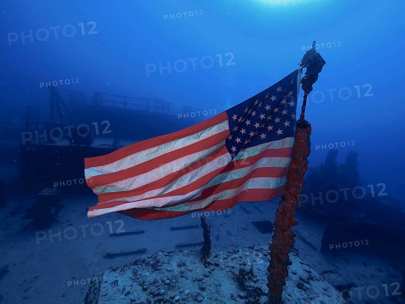 USA flag on a wreck under water, surrounded by deep blue. Dive site Wreck of the USS Spiegel Grove, John Pennekamp Coral Reef State Park, Key Largo, Florida Keys, Florida, USA
