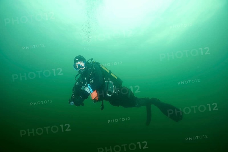 Diver underwater in greenish water with diving equipment during a safety stop. Dive site wreck of the Jura, Lake Constance, Bottighofen, Switzerland, Münsterlingen, Germany