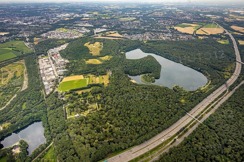 Aerial view, forest lake and slagheap Rheinpreussen, industrial area Gutenbergstraße, cemetery Lohmannsheide, Bärl, Duisburg, city limits Mörs, Ruhr area, North Rhine-Westphalia, Germany, motorway A42, burial site, slagheap, DE, Europe, cemetery, memorial, Geleucht Grubenlampe, commercial enterprises, commercial area, industrial area, commercial location, commercial use, Gottesacker, graves, burial ground, slag heap, slag heap landscape, slag heap sign, industrial area, industrial location, landmark, aerial view, aerial photography, aerial photography, Mörs, resting place, lake, symbol, overview, bird's-eye view, forest area, colliery slag heap, birds-eyes view, overview