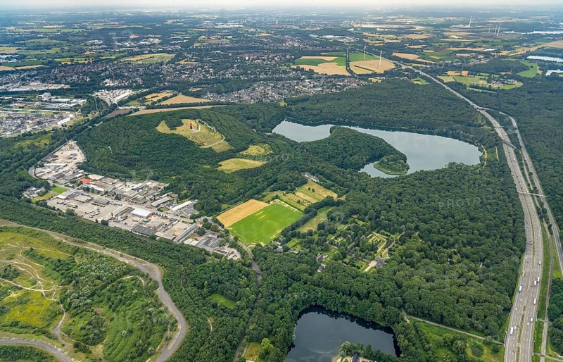 Aerial view, forest lake and slagheap Rheinpreussen, industrial area Gutenbergstraße, cemetery Lohmannsheide, Bärl, Duisburg, city limits Mörs, Ruhr area, North Rhine-Westphalia, Germany, motorway A42, burial site, slagheap, DE, Europe, cemetery, memorial, Geleucht Grubenlampe, commercial enterprises, commercial area, industrial area, commercial location, commercial use, Gottesacker, graves, burial ground, slag heap, slag heap landscape, slag heap sign, industrial area, industrial location, landmark, aerial view, aerial photography, aerial photography, Mörs, resting place, lake, symbol, overview, bird's-eye view, forest area, colliery slag heap, birds-eyes view, overview