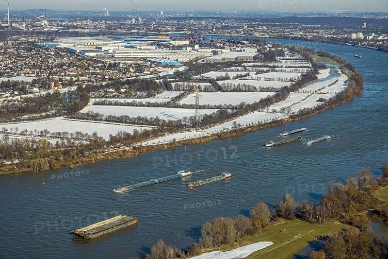 Aerial view, The Rhine with cargo ships at the Krupp Mannesmann smelting works, with a view of the Rheinaue Friemersheim, Mündelheim, Duisburg, Ruhr area, North Rhine-Westphalia, Germany, DE, Europe, aerial view, aerial photography, aerial photography, Rheinaue, snow, overview, bird's eye view, winter, birds-eyes view, cleared roads, overview