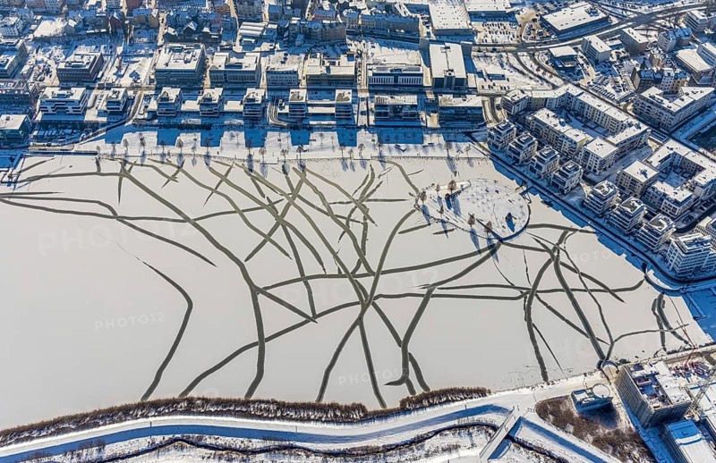 Aerial view, snow-covered Phoenix Lake, Hörde, Dortmund, Ruhr area, North Rhine-Westphalia, Germany, DE, Europe, commercial buildings, aerial view, aerial photography, aerial photography, snow, lake, overview, bird's eye view, winter, winter slump, winter landscape, birds-eyes view, overview, ice, ice surface, thin ice, break in ice, breaks in ice, snow-covered ice surface, artificial lake