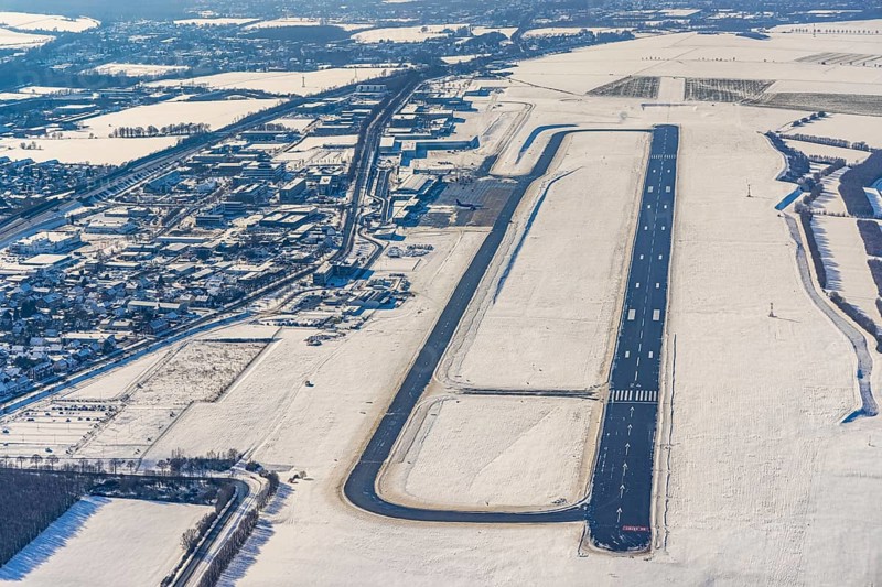 Aerial photo, Dortmund airport in winter, Wickede, Dortmund, Ruhr area, North Rhine-Westphalia, Germany, DE, Europe, flight mission, airport, airfield, runway, aerial photo, aerial photography, aerial photography, snow, runway, overview, bird's-eye view, winter, onset of winter, winter landscape, birds-eyes view, overview, cleared runway, taxiways terminal, general aviation, EDLW, General aviation, city limits Holzwickede