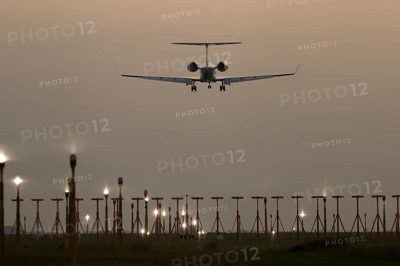 Bombardier Global business jet passenger aircraft in flight landing at sunset at London Stansted airport, Essex, England, United Kingdom