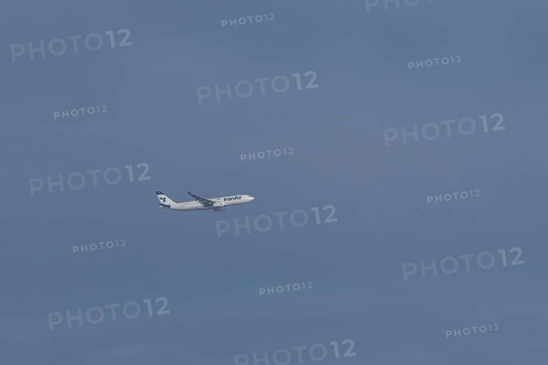 Jet passenger aircraft of Iran Air Airlines flying in a blue sky, England, United Kingdom