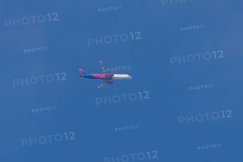 Airbus A321 jet aircraft of Wizz Air airlines in flight in a blue sky, England, United Kingdom