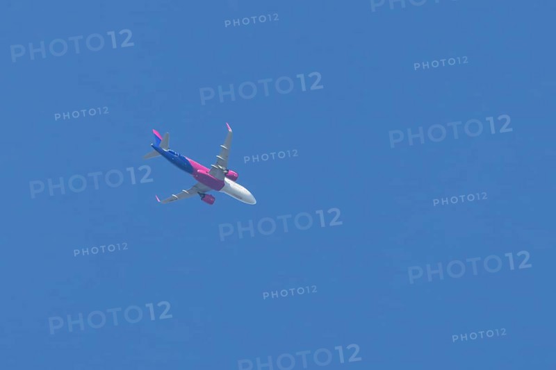 Airbus A321 jet aircraft of Wizz Air airlines in flight in a blue sky, England, United Kingdom