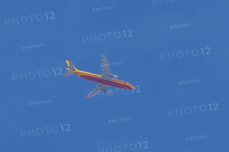 Boeing 767 jet aircraft of DHL cargo airlines in flight in a blue sky, England, United Kingdom