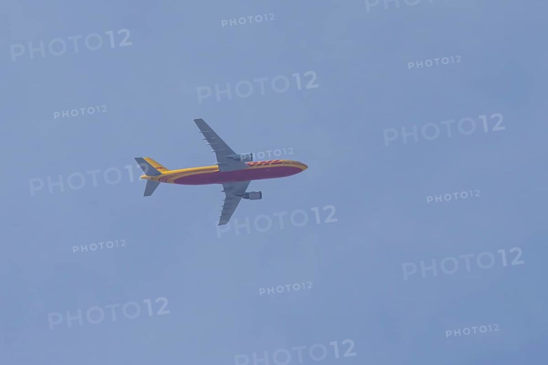 Boeing 767 jet aircraft of DHL cargo airlines in flight in a blue sky, England, United Kingdom