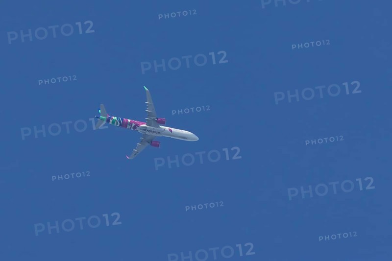 Airbus A321 jet aircraft of Wizz Air airlines in flight in a blue sky, England, United Kingdom