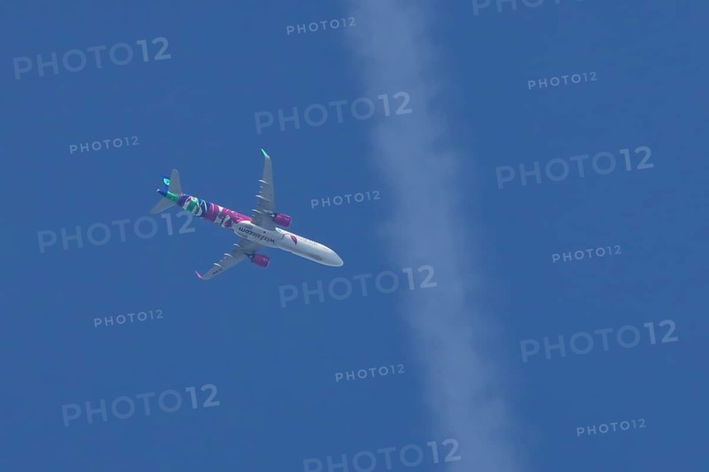 Airbus A321 jet aircraft of Wizz Air airlines in flight in a blue sky, England, United Kingdom