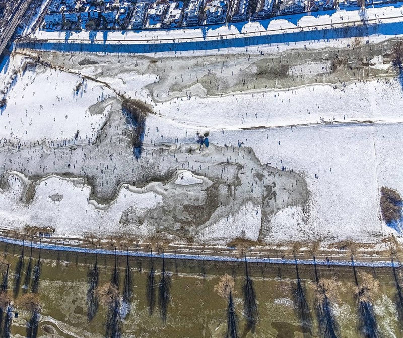 Aerial view, ice rink, ice skaters and pedestrians on frozen Rhine meadow in Lörrick near the Theodor-Heuss-Bridge, Niederkassel, Düsseldorf, Rhineland, North Rhine-Westphalia, Germany, DE, Europe, shapes and colours, aerial view, aerial photography, aerial photography, ice skating, snow, overview, bird's eye view, winter, birds-eyes view, overview