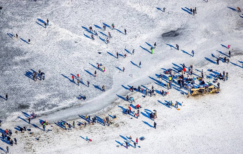 Aerial view, ice rink, ice skaters and pedestrians on frozen Rhine meadow in Lörrick near the Theodor-Heuss-Bridge, Niederkassel, Düsseldorf, Rhineland, North Rhine-Westphalia, Germany, DE, Europe, shapes and colours, aerial view, aerial photography, aerial photography, ice skating, snow, overview, bird's eye view, winter, birds-eyes view, overview
