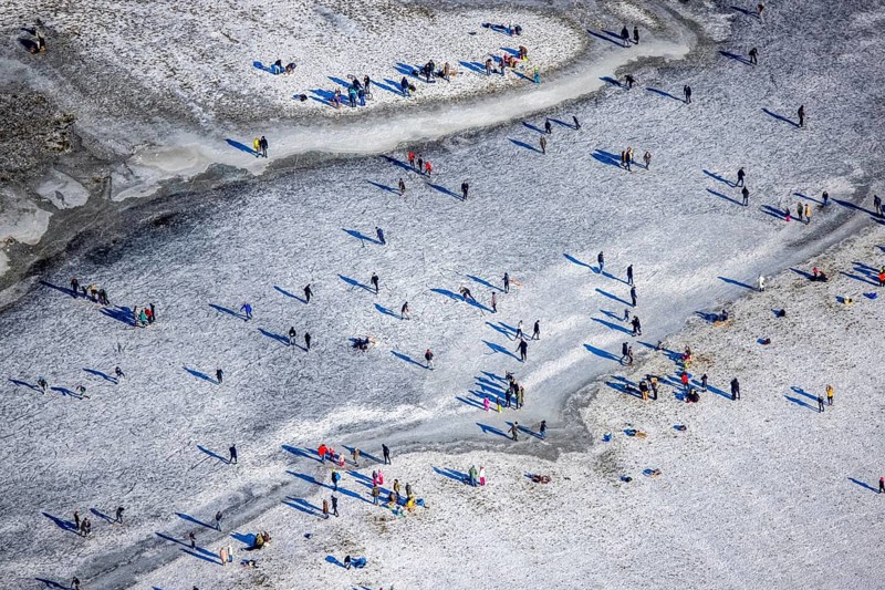 Aerial view, ice rink, ice skaters and pedestrians on frozen Rhine meadow in Lörrick near the Theodor-Heuss-Bridge, Niederkassel, Düsseldorf, Rhineland, North Rhine-Westphalia, Germany, DE, Europe, shapes and colours, aerial view, aerial photography, aerial photography, ice skating, snow, overview, bird's eye view, winter, birds-eyes view, overview