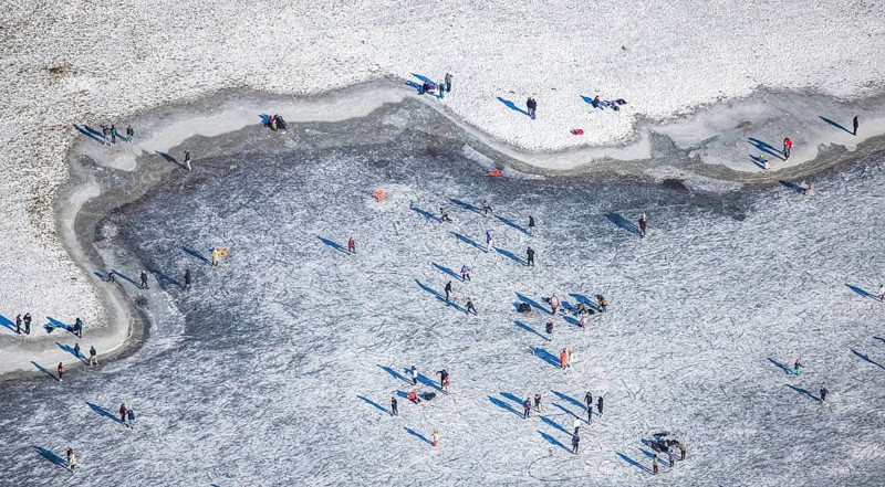Aerial view, ice rink, ice skaters and pedestrians on frozen Rhine meadow in Lörrick near the Theodor-Heuss-Bridge, Niederkassel, Düsseldorf, Rhineland, North Rhine-Westphalia, Germany, DE, Europe, shapes and colours, aerial view, aerial photography, aerial photography, ice skating, snow, overview, bird's eye view, winter, birds-eyes view, overview
