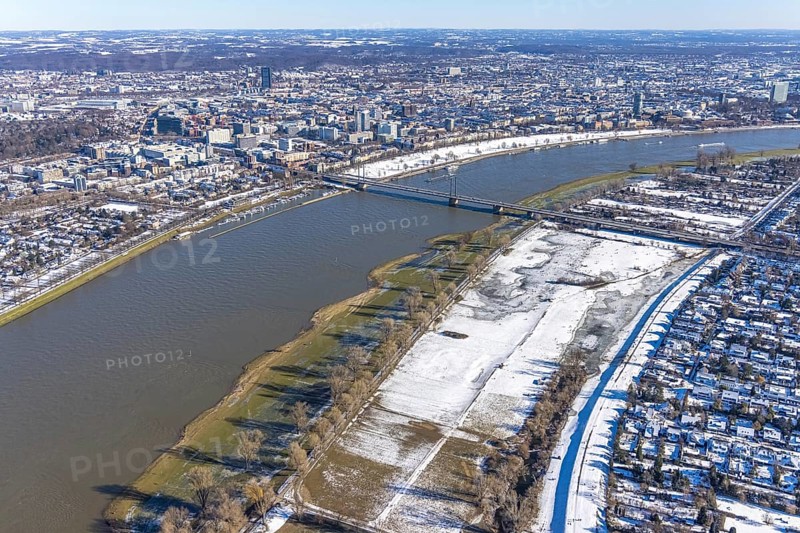 Aerial view, ice rink, ice skaters and pedestrians on frozen Rhine meadow in Lörrick near the Theodor-Heuss-Bridge, river Rhine, Niederkassel, Düsseldorf, Rhineland, North Rhine-Westphalia, Germany, DE, Europe, shapes and colours, aerial view, aerial photography, aerial photography, ice skating, snow, overview, bird's eye view, winter, birds-eyes view, overview