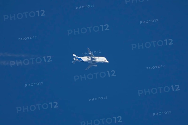Airbus A300-600ST Super Transporter or Beluga aircraft in flight in a blue sky with vapour trails or contrails behind, England, United Kingdom