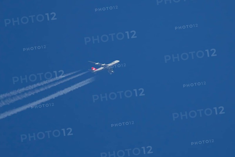 Boeing 747 Jumbo jet cargo aircraft of Cargolux airlines in flight in a blue sky with vapour trails or contrails behind, England, United Kingdom