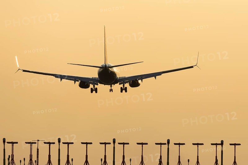 Boeing 737 jet passenger aircraft of Ryanair airlines landing over runway lights at sunset, London Stansted airport, Essex, England, United Kingdom