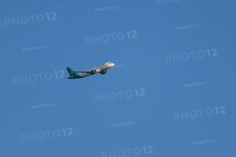 Airbus passenger jet aircraft of Aer Lingus flying in a blue sky, England, United Kingdom