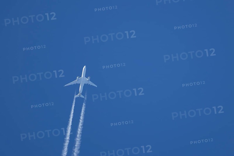 Airbus A350-900 passenger jet aircraft of Singapore airlines flying with a vapour trial or contrail behind in a blue sky, England, United Kingdom