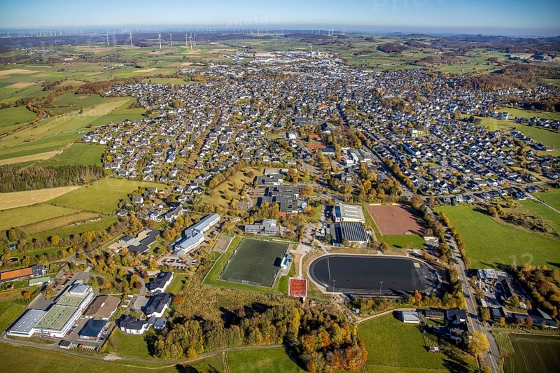 Aerial view, town view with sports field and Gymnasium Petrinum Brilon as well as vocational college for economics and administration of the Hochsauerlandkreis and wind farm in the background in Brilon, Sauerland, North Rhine-Westphalia, Germany, Brilon, DE, Europe, distant view, property tax, real estate, aerial view, aerial photography, aerial photography, town view, townscape, overview, bird's-eye view, wind energy, wind turbine, wind power, wind power plant, wind farm, wind turbines, residential area, residential area, residential buildings, residential quality, residential neighbourhood, housing estate, birds-eyes view, overview