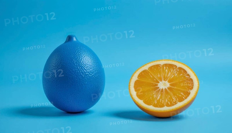A vibrant image showcasing a blue lemon next to a half-cut orange, set against a bright blue backdrop, creating a striking contrast, AI generated