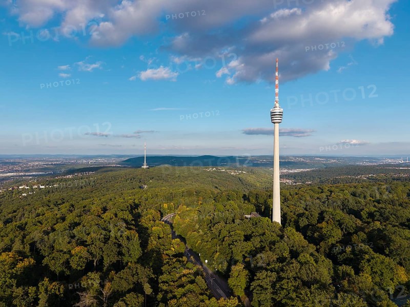 Television tower rises out of lush forest, surrounded by blue sky and decorated with clouds, Stuttgart-Degerloch, Baden-Württemberg, Germany