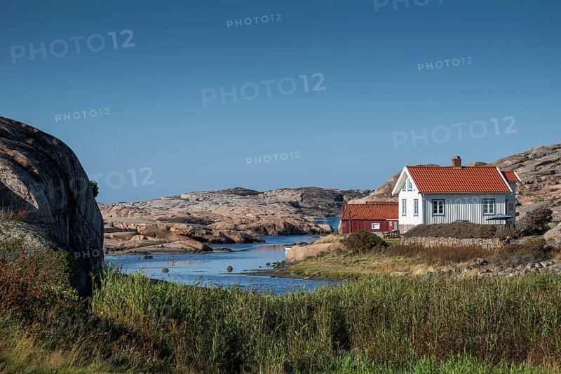 White houses and falun red boathouse on grassy shore, Bohus granite, rocky coast, Ramsvik, Naturreservat Ramsviklandet, Bohuslän, Skagerrak, Sotenäs, Västra Götalands län, Sweden