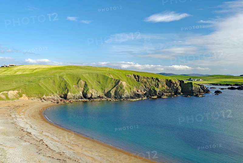 Sandy beach beach and blue sea with green cliffs under a clear sky, Eshaness, Shetland Islands, Scotland, United Kingdom