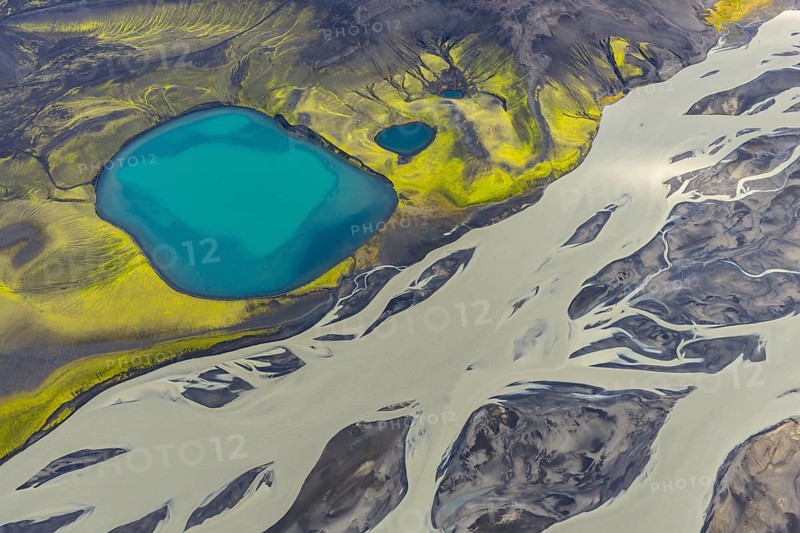 Turquoise crater lake next to intertwined glacial river, Icelandic Highlands, Iceland
