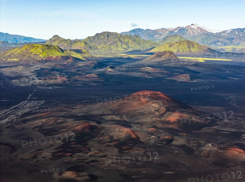 Volcanic landscape with black sand desert and red mountains, moss-covered mountains in the background, Icelandic Highlands, Iceland