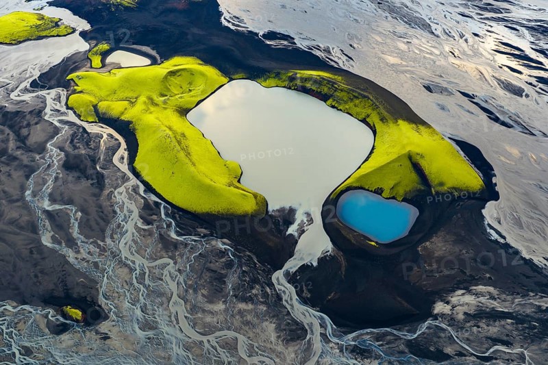 Turquoise-coloured crater lake with moss-covered crater rims in the Icelandic highlands, surrounded by glacial rivers, Iceland