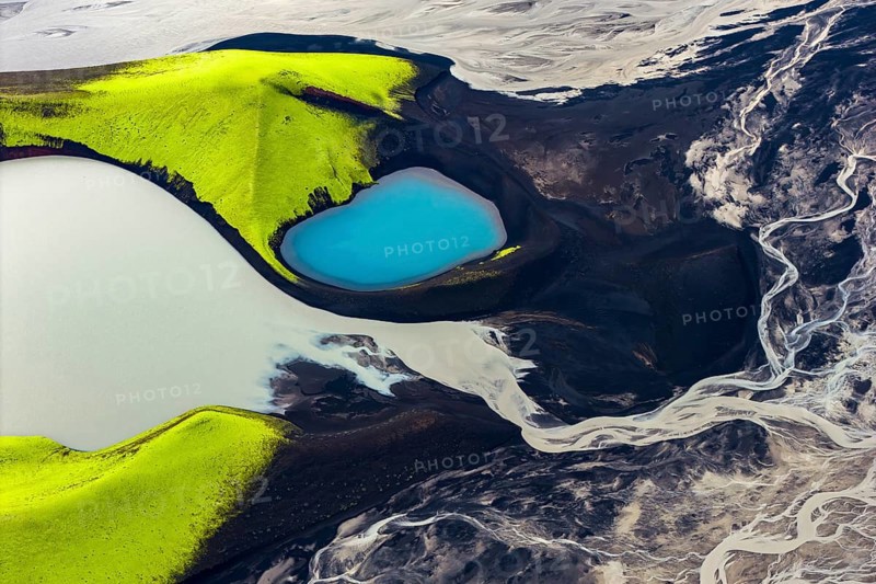 Turquoise-coloured crater lake with moss-covered crater rims in the Icelandic highlands, surrounded by glacial rivers, Iceland