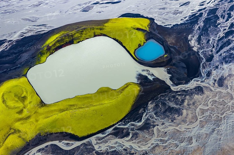 Turquoise-coloured crater lake with moss-covered crater rims in the Icelandic highlands, surrounded by glacial rivers, Iceland