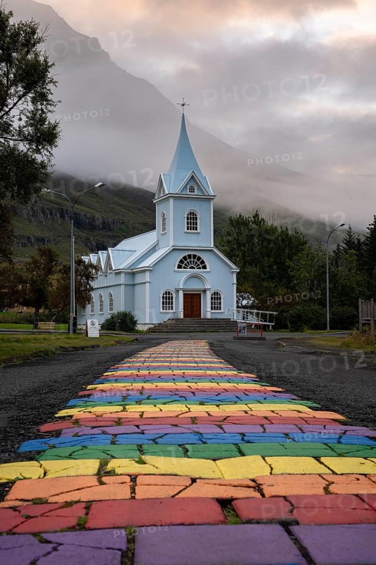 Church with rainbow pedestrian path in the town of Seyðisfjörður, East Iceland, Iceland
