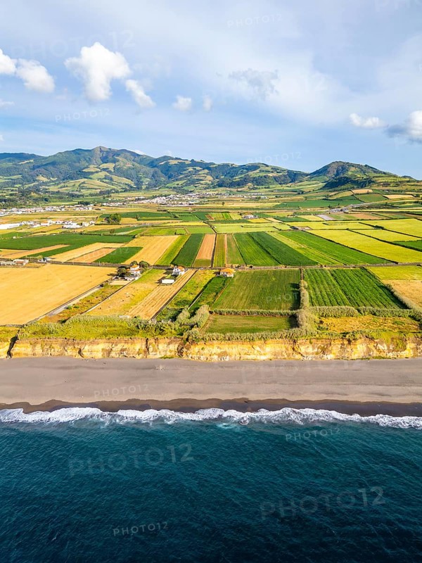Santa Barbara Beach, Green Lush Fields with Pasturelands and Atlantic Ocean. Mountains on Background. Azores, Sao Miguel Island. Portugal. Aerial View