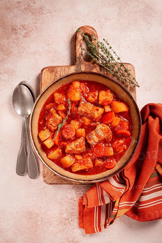 Meat goulash with potatoes and carrots, sweet peppers, in a saucepan, top view, traditional Hungarian soup, homemade, no people