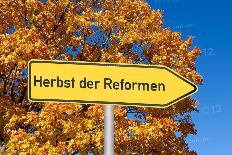 (Photomontage) Directional arrow with the inscription HERBST DER REFORMEN in front of an autumn-coloured deciduous tree