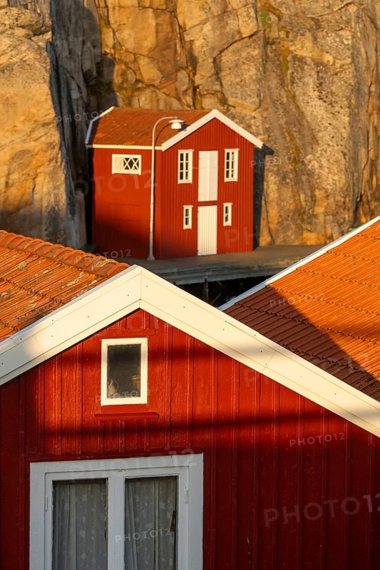 Falun red boathouses between rocks in the harbour of Smögen, Smögenbryggan, Västra Götalands Län, Bohuslän, Sweden