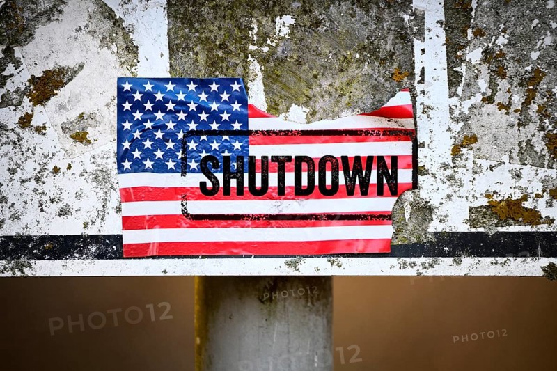 Torn sticker of US flag with shutdown printed on it, photomontage