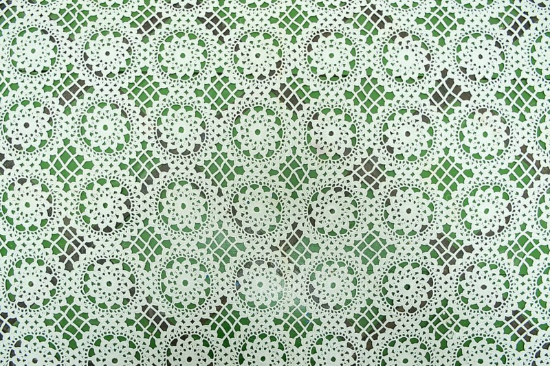 White floral fabric crocheted from cotton threads, textured background