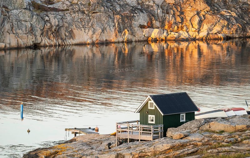 Small green boathouse, evening mood at sunset, Smögen, Smögenbryggan, Västra Götalands Län, Bohuslän, Sweden
