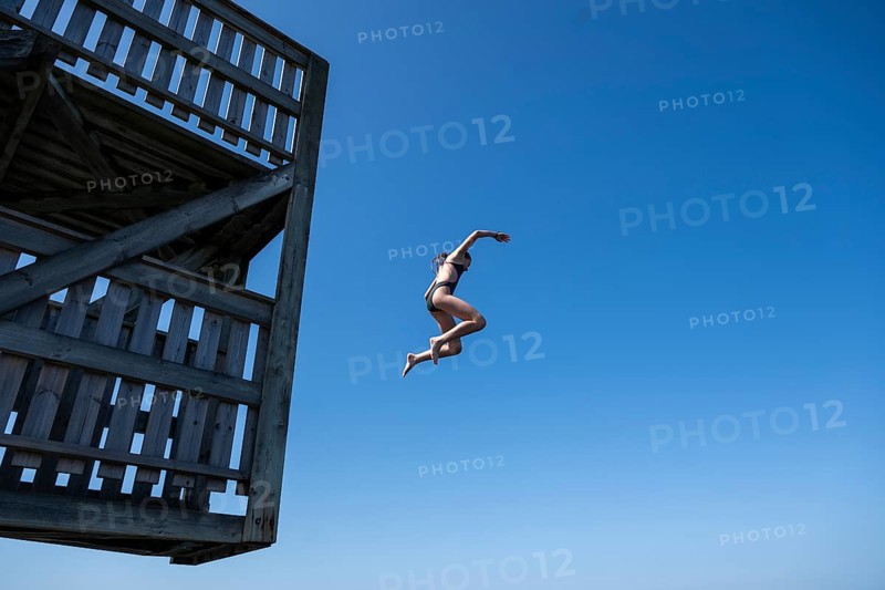 Girl jumping from a high wooden diving platform into the sea, lido, Fjällbacka, Bohuslän, West Sweden, Sweden
