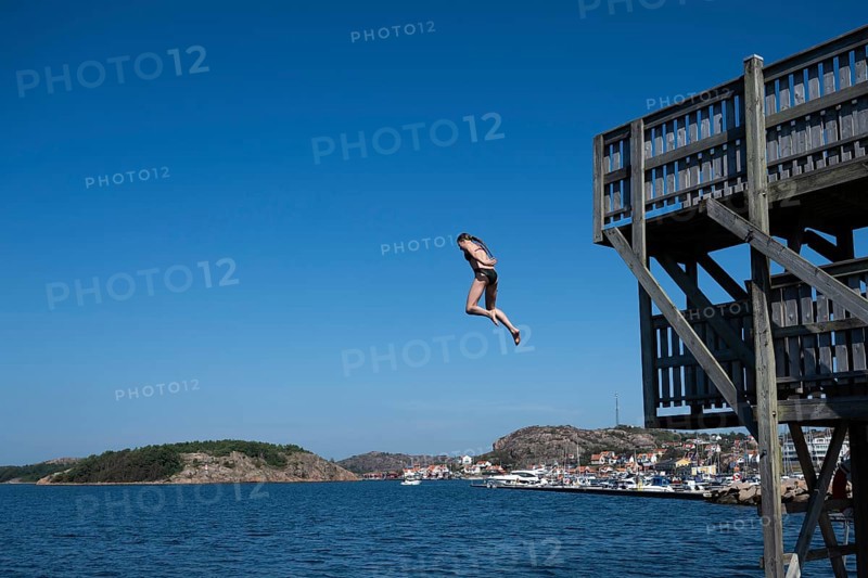Girl jumping from a high wooden diving platform into the sea, lido, Fjällbacka, Bohuslän, West Sweden, Sweden