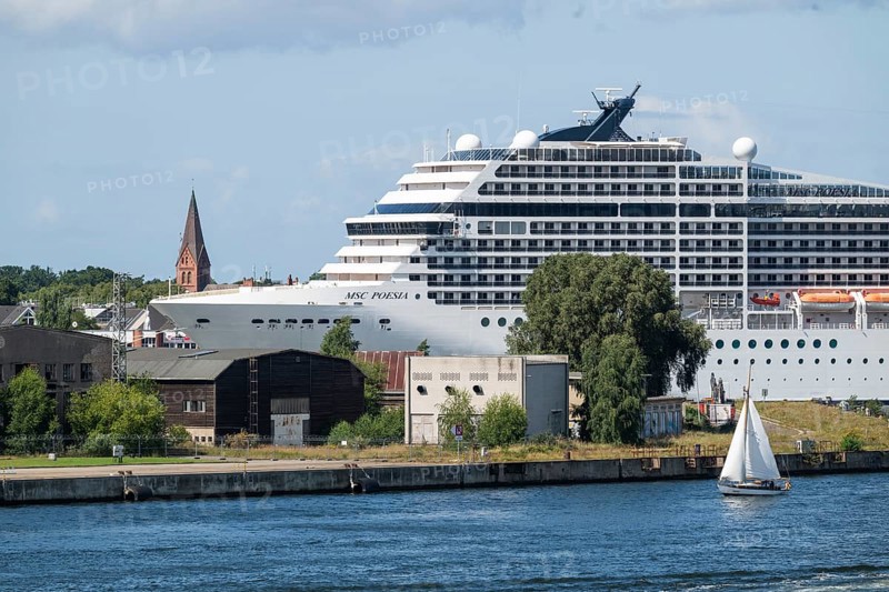 Large cruise ship MSC Poesia in the harbour, church tower in the background, Warnemünde, Rostock, Mecklenburg-Vorpommern, Germany